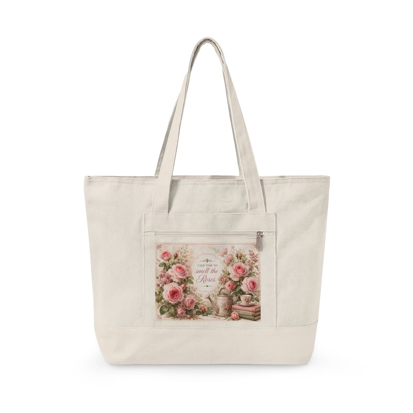 An off-white canvas tote bag with dual shoulder straps and a front zippered pocket featuring a vintage-style floral print with pink roses and cursive text.